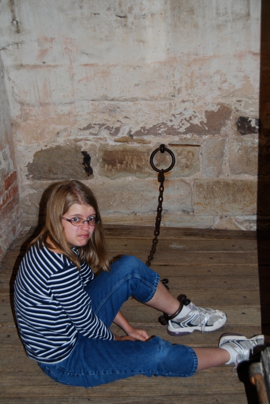 Laura tries the leg irons at the Richmond Gaol.